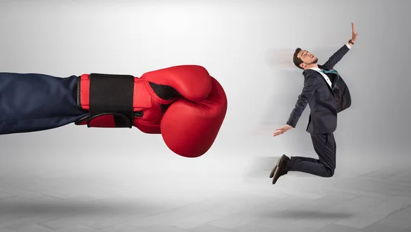 Giant hand ger en kick till en liten affärsman — Stockfoto