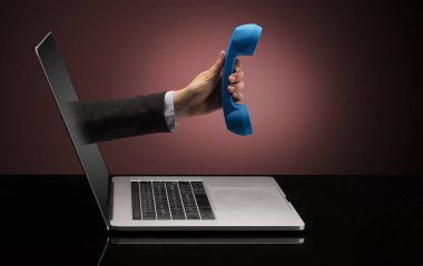 El ile bir dizüstü bilgisayar dışarı geliyor telefon