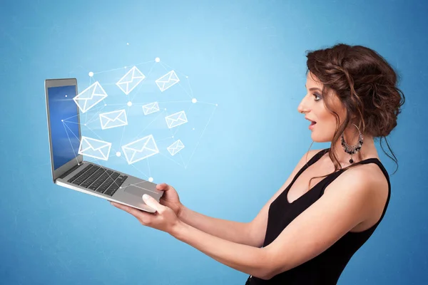 Woman holding laptop with online symbols — Stock Photo, Image