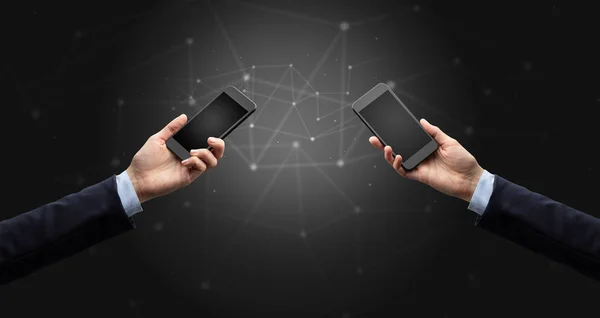 Primer plano de dos manos sosteniendo teléfonos inteligentes — Foto de Stock