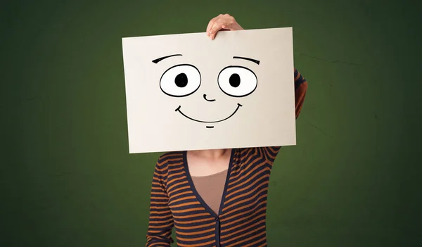Student, trzymając papier ze śmiechem emotikon przed jego twarz — Zdjęcie stockowe