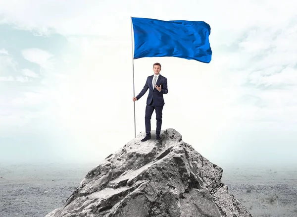 Empresario en la cima de una bandera de la montaña — Foto de Stock