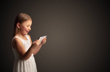 Tablet ile koyu arka plan kullanarak sevimli küçük kız