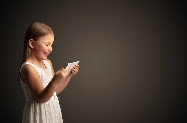 Cute little girl using tablet with dark background Stock Image