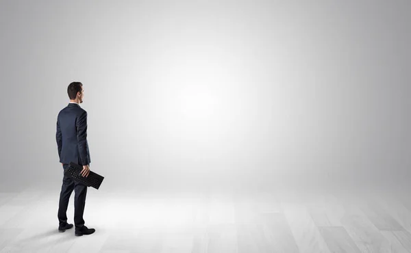 Man with object in his hand in an empty space — Stock Photo, Image