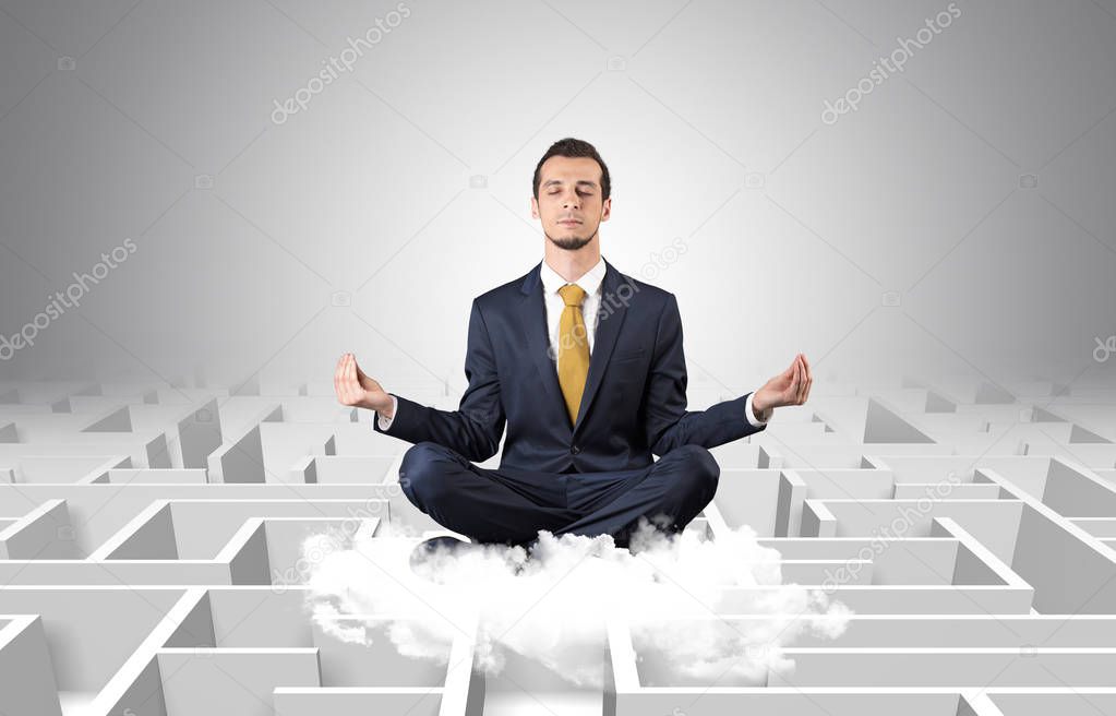 Businessman meditates on a cloud with maze concept