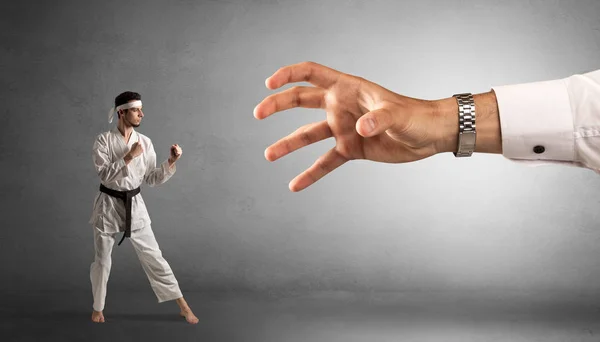 Stor hand fånga små karate man — Stockfoto