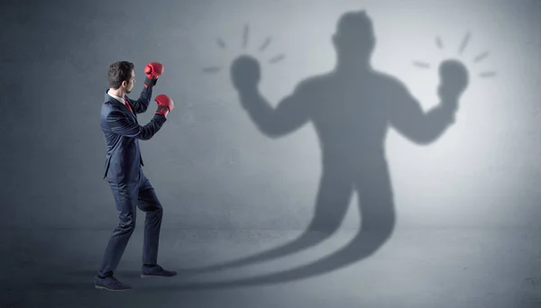 Businessman fighting with his unarmed shadow — Stock Photo, Image