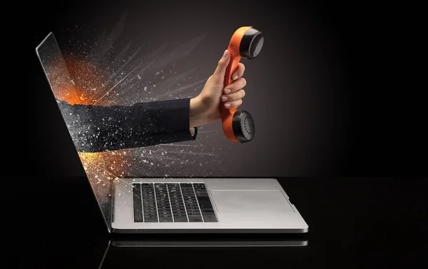 Hand with phone coming out of a laptop — Stock Photo, Image