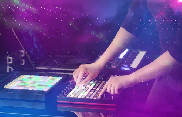 Смешивание музыки на миди-контроллере с клубными цветами вокруг — стоковое фото