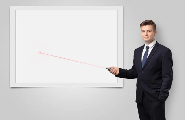 Businessman with laser pointer and copyspace white blackboard — Stock Photo, Image