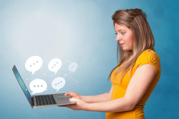 Woman holding laptop with speech bubbles — Stock Photo, Image