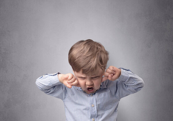 Adorable little boy in front of an empty wall