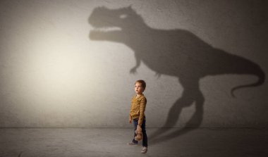 Sevimli çocuk arkasında dinazorların gölge