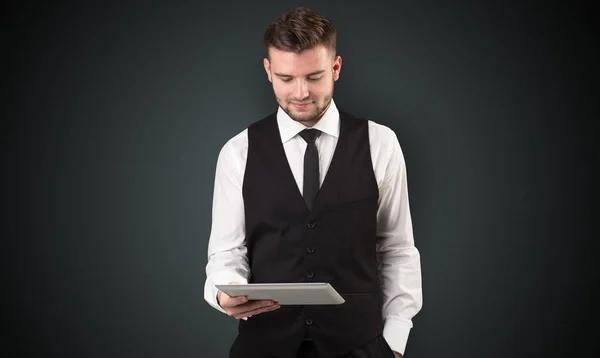 Businessman holding tablet with dark background — Stock Photo, Image