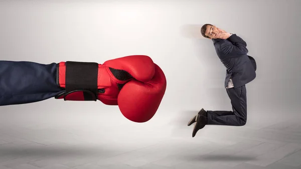 Mão gigante dá um chute a um pequeno empresário — Fotografia de Stock
