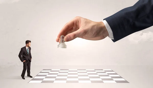 Μικρό επιχειρηματία παίζει σκάκι με ένα μεγάλο χέρι έννοια — Φωτογραφία Αρχείου