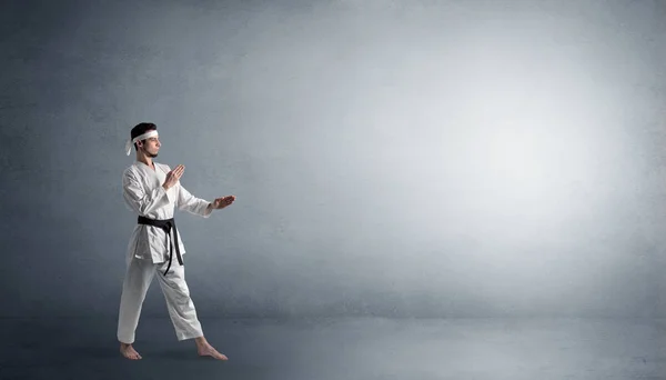 Kleiner Karate-Mann kämpft in einem leeren Raum — Stockfoto