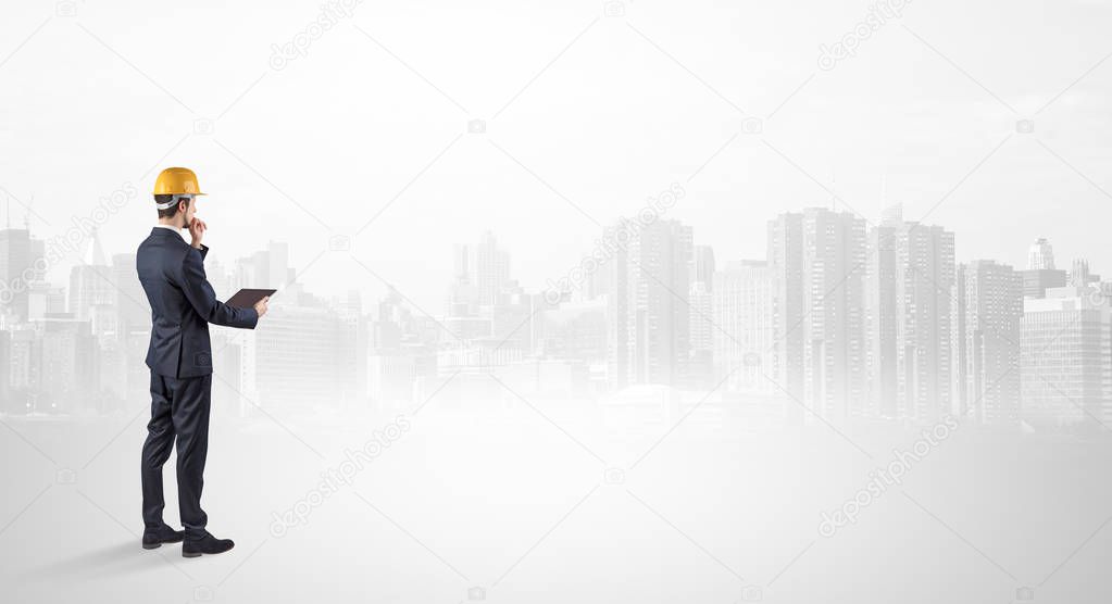 Architect standing and  looking at a big city panorama