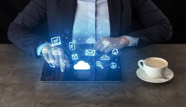 Yukarıdaki uygulama simgeleriyle tablet üzerinde çalışan iş kadın