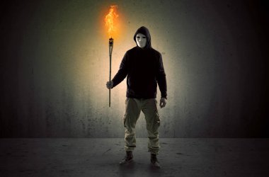 Boş bir alanda flambeau yanma ile yürüyen adam