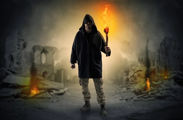 Man coming with burning flambeau at a catastrophe scene concept