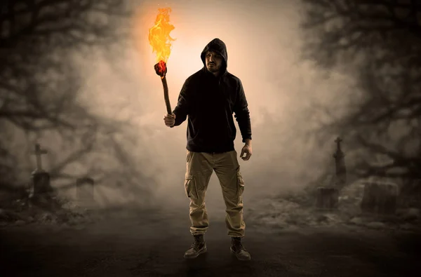 Man coming out from a thicket with burning flambeau — Stock Photo, Image