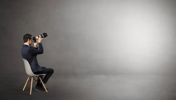 Businessman staying in an empty room with stuffs on his lap — Stock Photo, Image