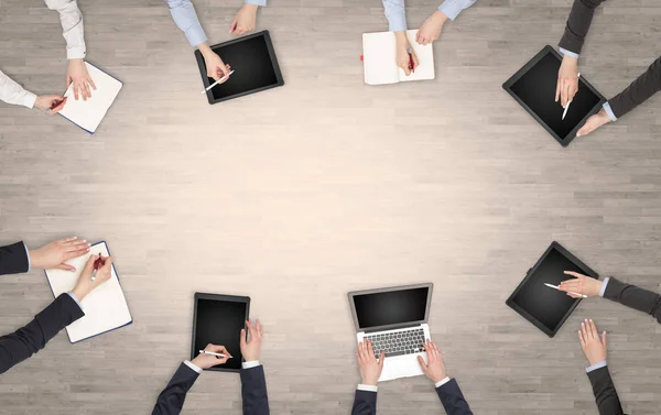 Group of people with devices in hands having desk discussion and working on laptops, tablets in team — Stock Photo, Image