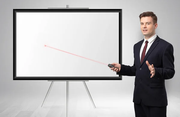 Businessman with laser pointer and copyspace white wall — Stock Photo, Image