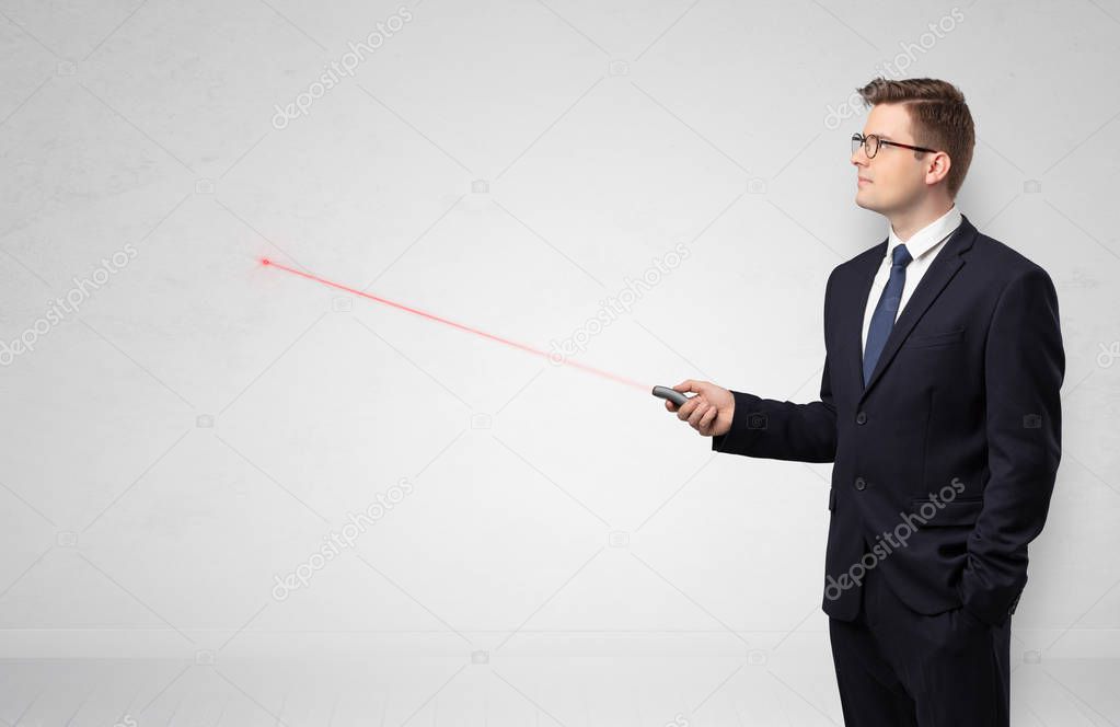 Businessman with laser pointer and copyspace white wall