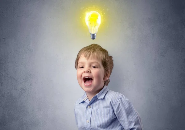 Niño pequeño reflexiona con bulbo sobre su cabeza — Foto de Stock