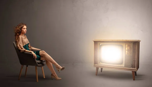 Young lady watching to a vintage television — Stock Photo, Image