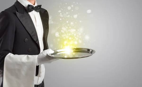 Waiter serving mysterious light on tray — Stock Photo, Image