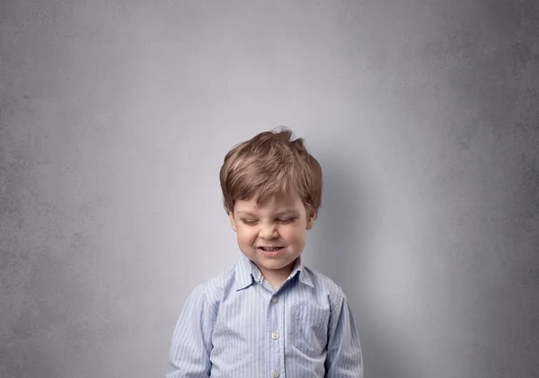 Entzückender kleiner Junge vor einer leeren Wand — Stockfoto