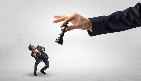 Большая рука с шахматистом вниз небольшой слабой концепции бизнесмена
