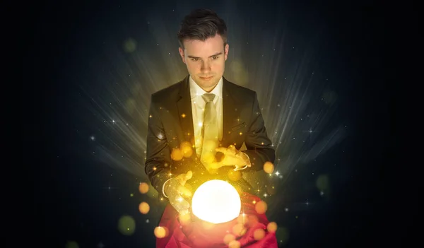 Businessman  sitting with sparkling magic ball — Stock Photo, Image