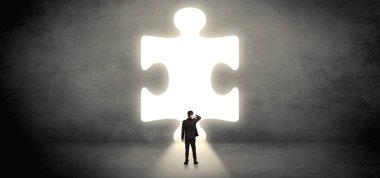 Bir büyük bulmaca parçası önünde duran işadamı