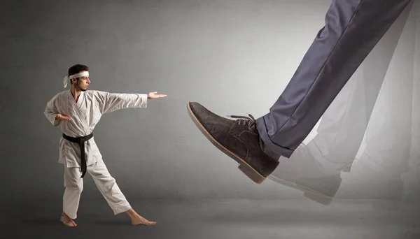 Großer Fuß tritt kleinen Karate-Mann — Stockfoto