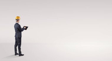 Boş bir alanda duran ve bir plan tutan mimar