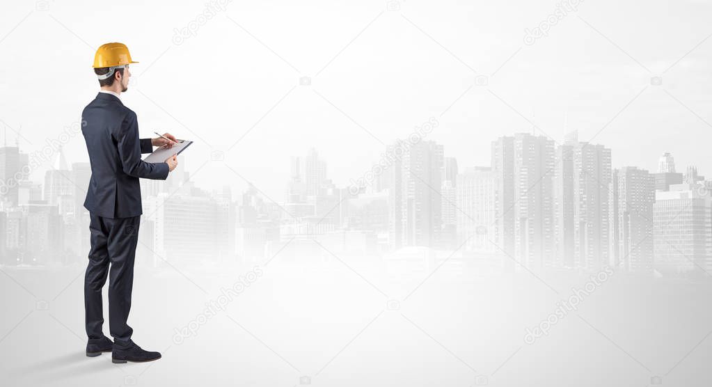 Architect standing and  looking at a big city panorama