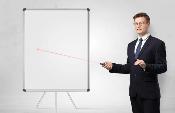 Businessman with laser pointer and copyspace white blackboard — Stock Photo, Image