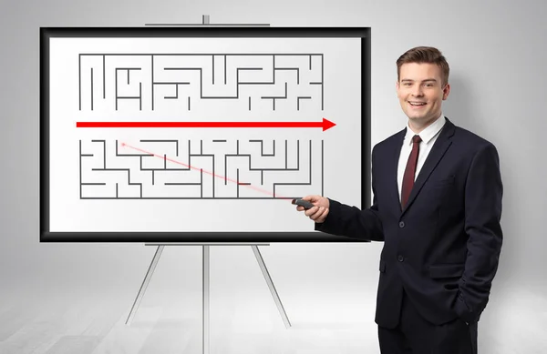 Empresário apresentando saída potencial de um labirinto — Fotografia de Stock