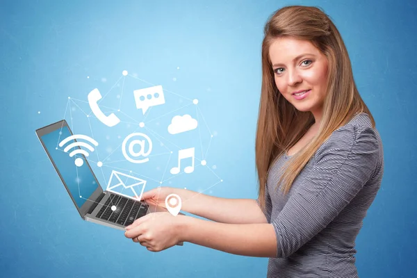 Woman holding laptop with online symbols — Stock Photo, Image