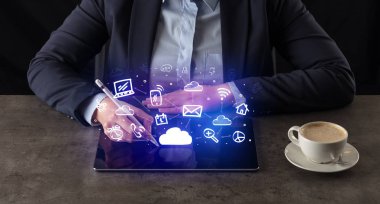 Yukarıdaki uygulama simgeleriyle tablet üzerinde çalışan iş kadın