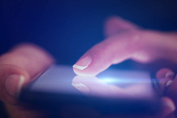 Finger touching phone with dark background