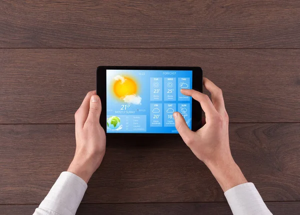 Hand checking weather on tablet — Stock Photo, Image