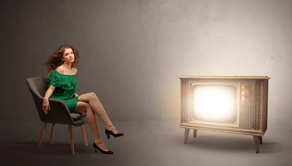 Jeune femme regardant une télévision vintage — Photo