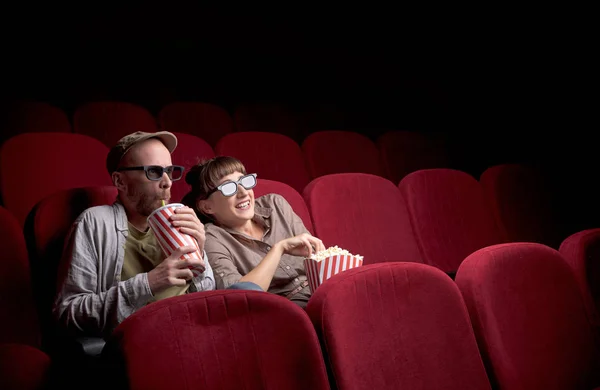 Young couple sitting at red movie theatre — Stock Photo, Image