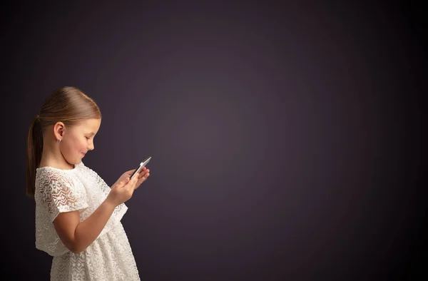 Cute little girl using tablet with dark background Stock Photo